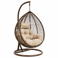 Poltrona sospesa in rattan e acciaio con cuscino beige
