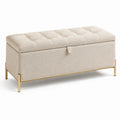 Cassapanca in tessuto beige con gambe in metallo dorato